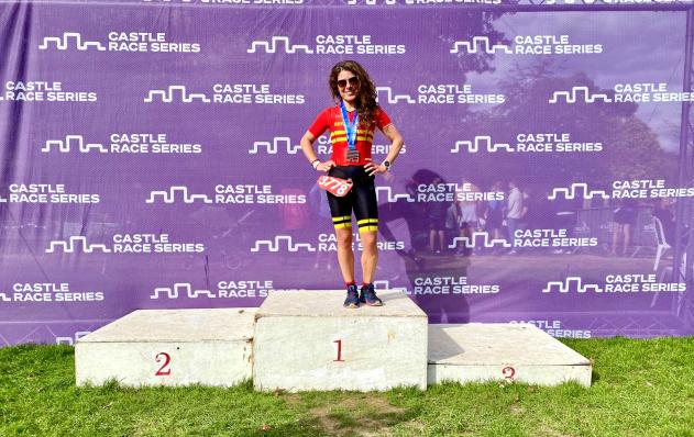 Monica Mundo standing on the winner's podium after triathlon